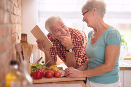 An elderly couple cooking together.