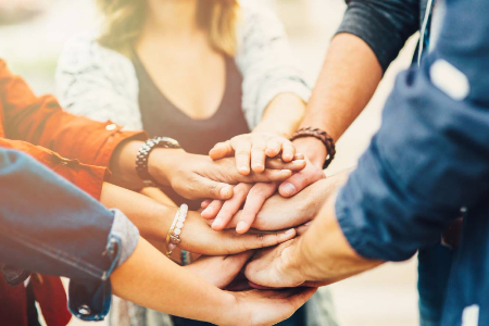 A group of hands on top of each other.