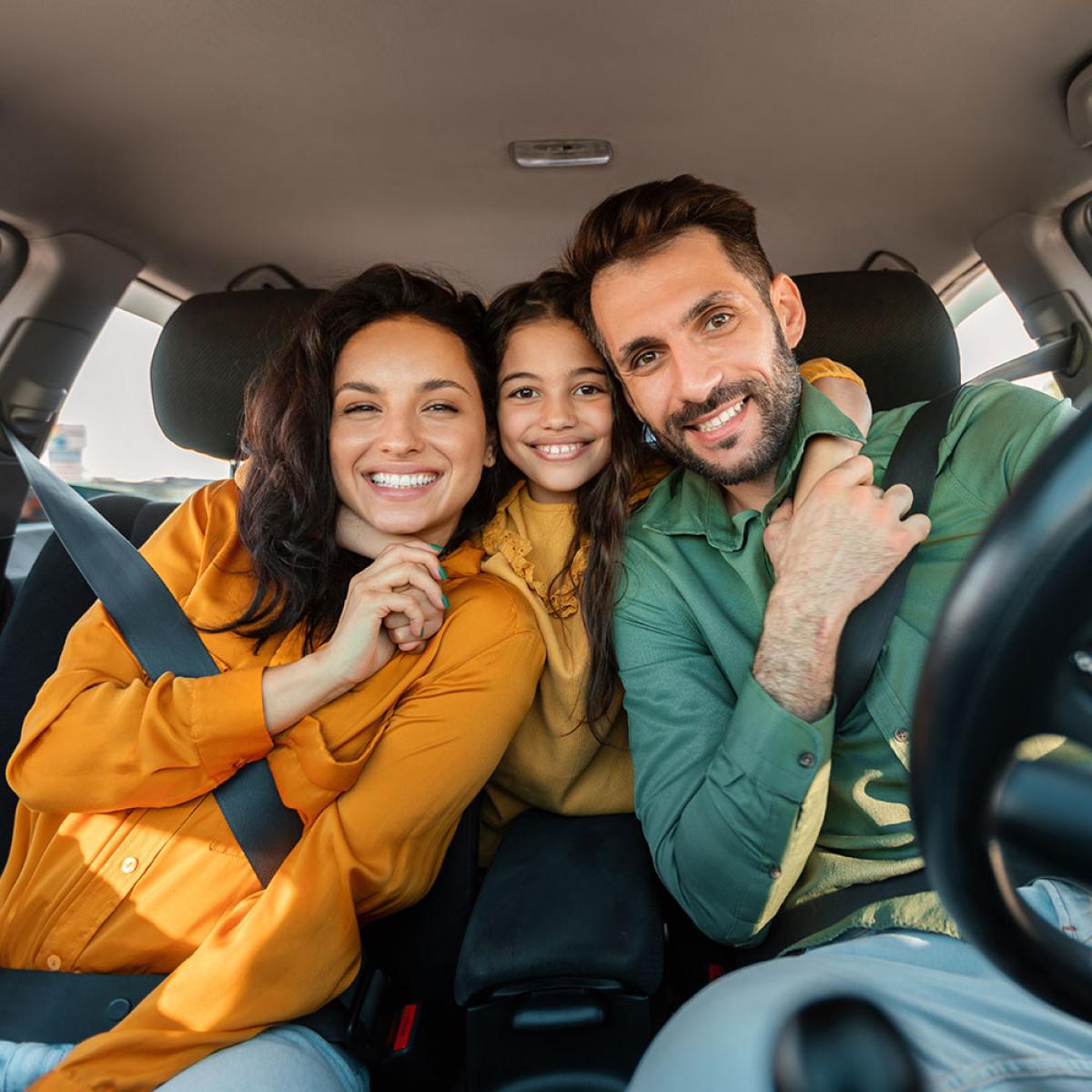Smiling family in new car