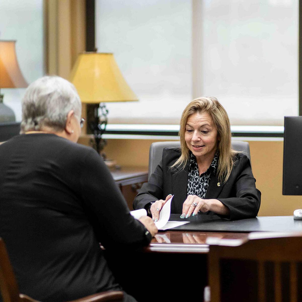 bank employee helping customer with papers