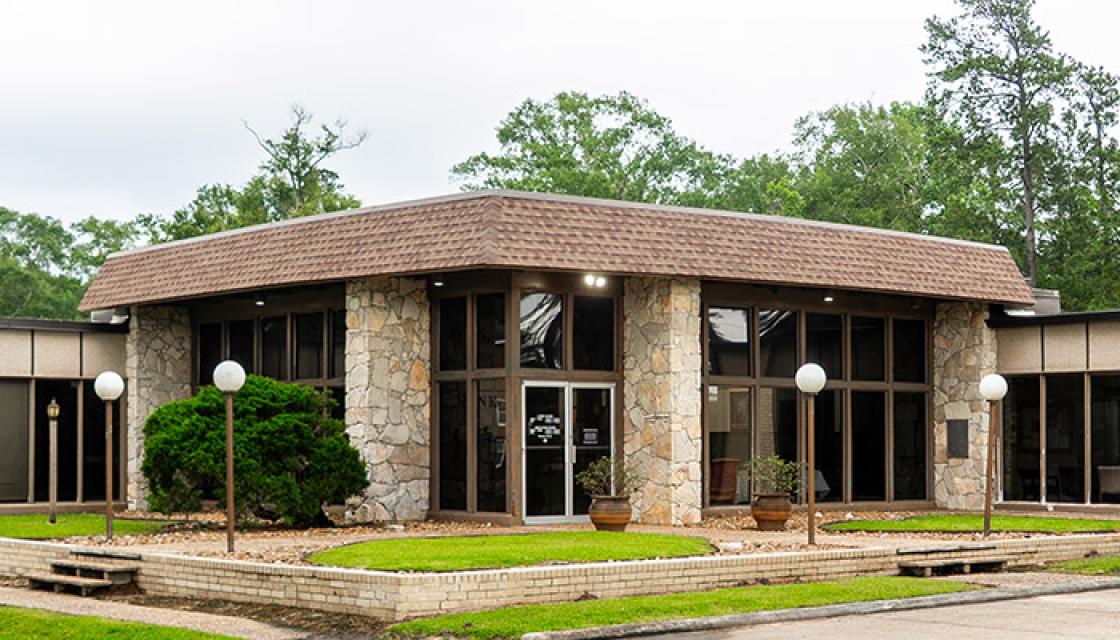 Entrance to large tan stone building with flat roof